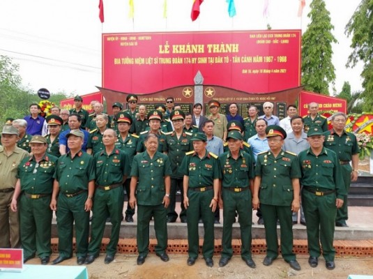 Các đại biểu chụp ảnh lưu niệm cùng CCB Trung đoàn 174 (Đoàn Cao - Bắc - Lạng) tại Bia ghi danh tưởng niệm các liệt sĩ thuộc Trung đoàn 174 tại Nghĩa trang liệt sĩ huyện Đắk Tô. (ảnh: baovanhoa.vn)