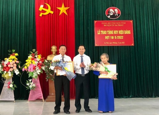 Đồng chí Nguyễn Minh Tuấn - Tỉnh ủy viên, Bí thư Huyện ủy trao Huy hiệu Đảng cho 2 đảng viên tiêu biểu.