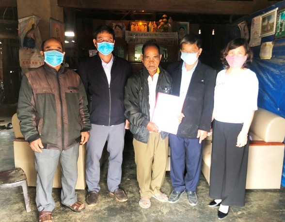 Đồng chí Trần Lạc trao tiền hỗ trợ cho ông A Hiết - ở xã Đắk Tờ Kan, huyện Tu Mơ Rông