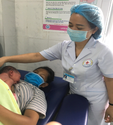 Nữ hộ sinh Trung tâm Y tế huyện Đăk Glei thực hiện chăm sóc da kề da sau sinh cho bé