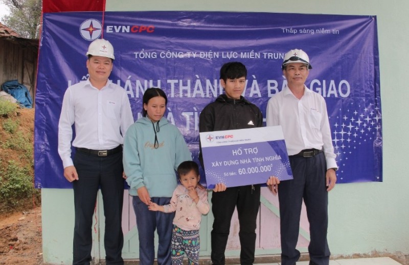 Giám đốc Công ty Điện lực Kon Tum Nguyễn Văn Hạnh (thứ nhất bên phải) trao nhà tình nghĩa cho hộ gia đình ông A Nghiệp, thôn Tân Rát, xã Ngọc Linh, huyện Đăk Glei