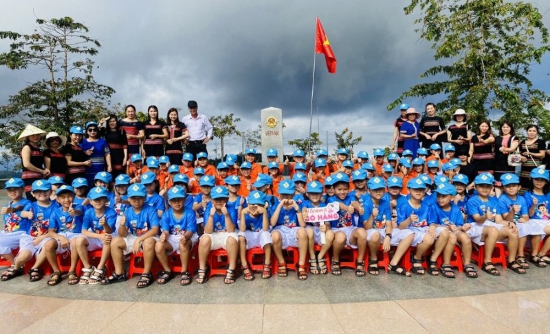 Giáo viên và các em học sinh tại cột mốc Nga ba biên giới Việt Nam-Lào-Campuchia