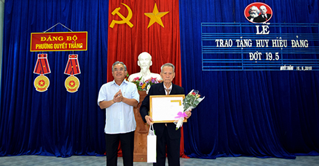 Đồng chí Nguyễn Văn Hùng trao Huy hiệu 70 năm tuổi Đảng cho đồng chí Lê Ngọc Câu, đảng viên hiện đang sinh hoạt tại chi bộ 3, Đảng bộ phường Quyết Thắng (thành phố Kon Tum).